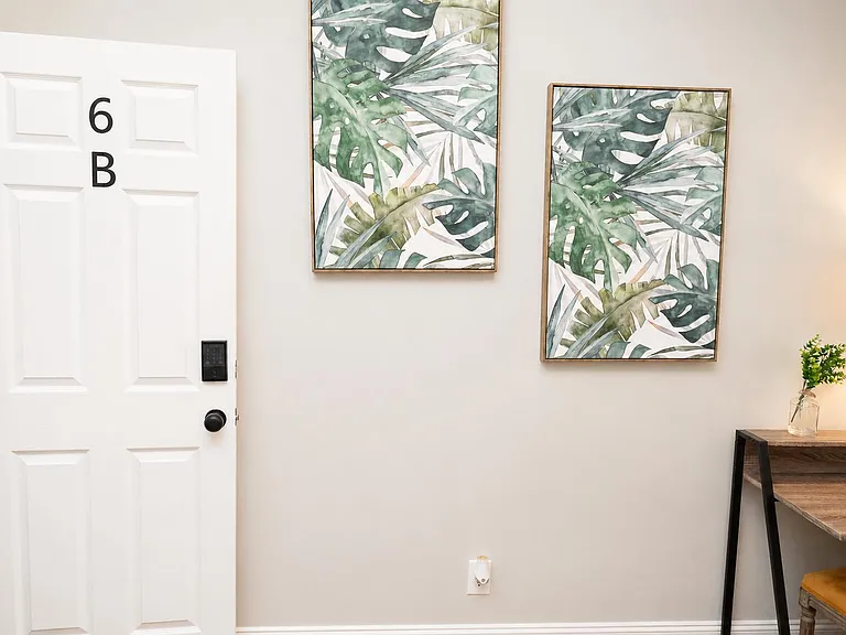 Entry area with keyed door access, wall art accents, and a compact desk nook for studying or remote work.