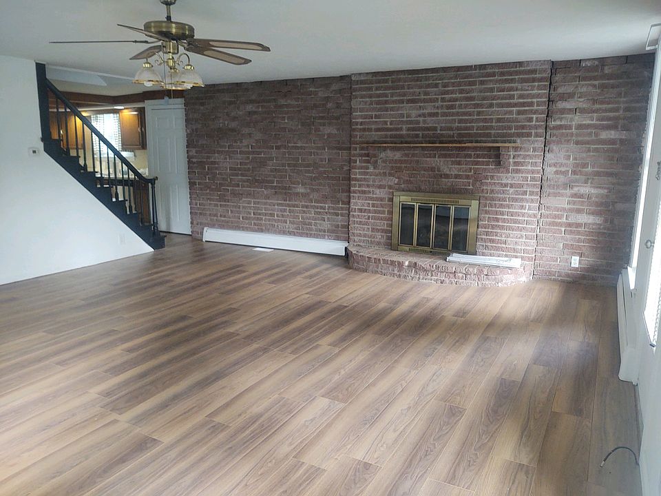 Huge living room features brick wall and charming original fireplace( no longer in use) but lovely mantle to hang stockings and decorate.