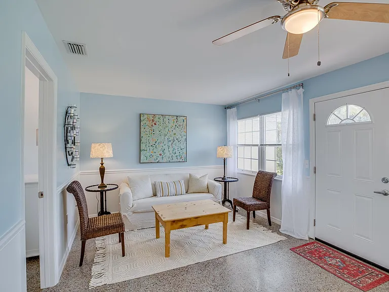 Large furnished living room with terrazzo floor, adjacent to two bedrooms