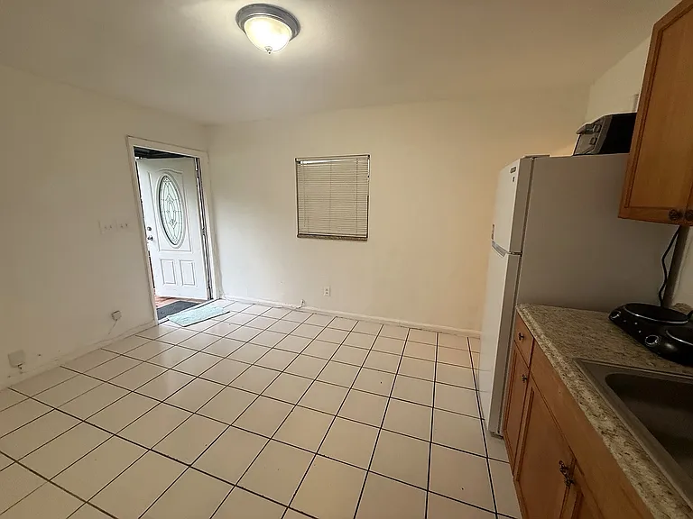 Living area viewed toward the cottage entrance, showing the open floor plan, natural light and adjoining kitchenette.