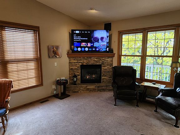 Large living room with a gas fireplace. South windows have louvered blinds. Flat screen TV's will fit over the fireplace.