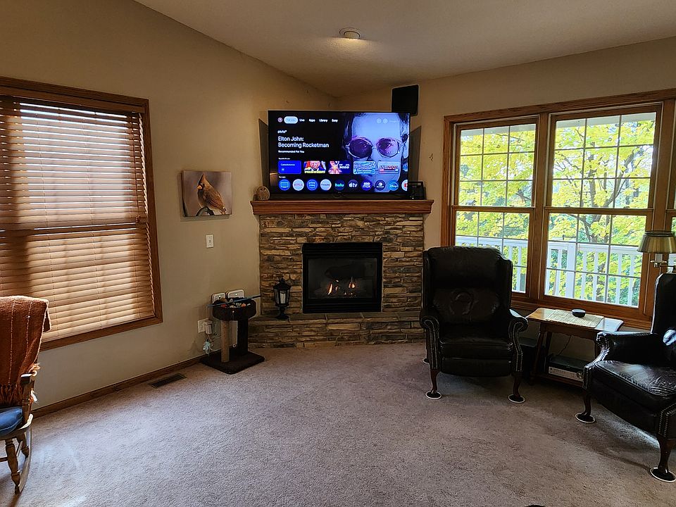 Large living room with a gas fireplace. South windows have louvered blinds. Flat screen TV's will fit over the fireplace.