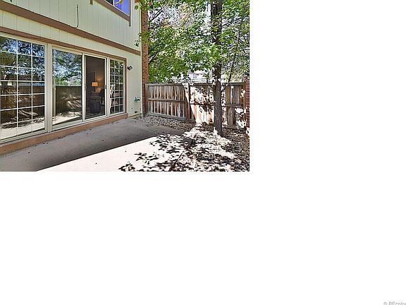 Private fenced yard with patio and gate leading to grassy common area