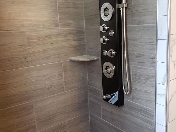 Huge tiled shower with modern faucet