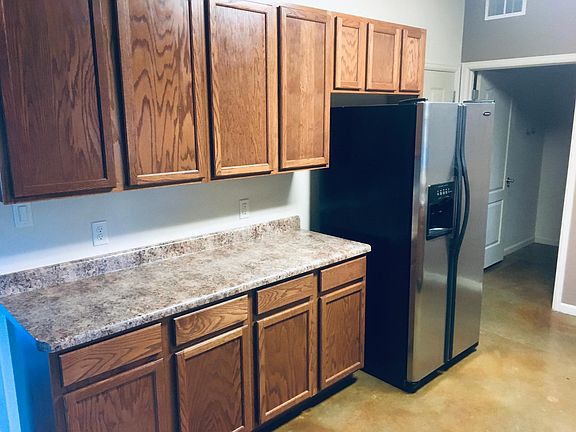 South side of kitchen. Open door goes to laundry room. Door at the side of refrig goes to garage