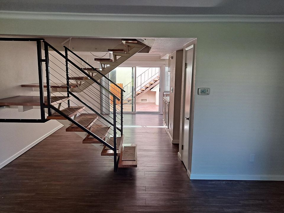 View from Living room to dining area and staircase to upstairs bedrooms and bath.
