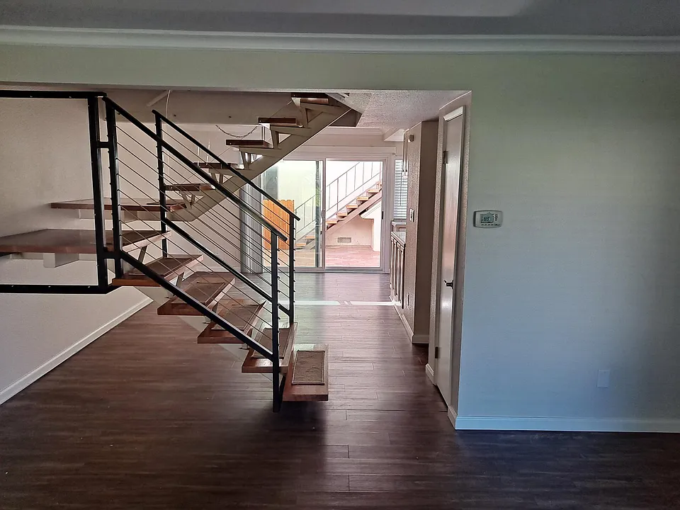 View from Living room to dining area and staircase to upstairs bedrooms and bath.