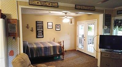 FAMILY ROOM VIEW IN APARTMENT WITH FRENCH DOORS OUT TO SCREENED IN PORCH CURRENTLY HAS EXTRA BED IN IT