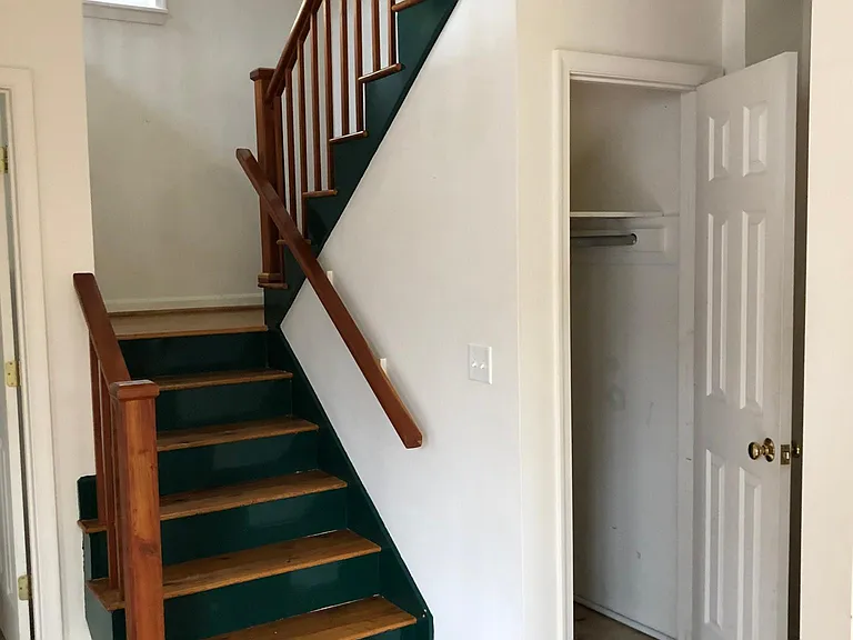 Stairy way next to powder room, coat closet.