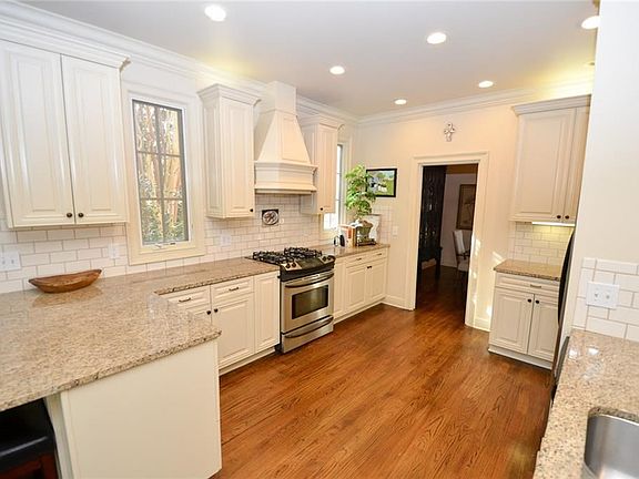 Bright and airy kitchen with lots of windows, recessed lighting, above cabinet lighting and under cabinet lighting.  Tiled back splash, granite countertops, two sit down bars, gas stove/dual fuel oven. Pocket door leads to a gorgeous dining room.  Kitchen opens to the Living Room.