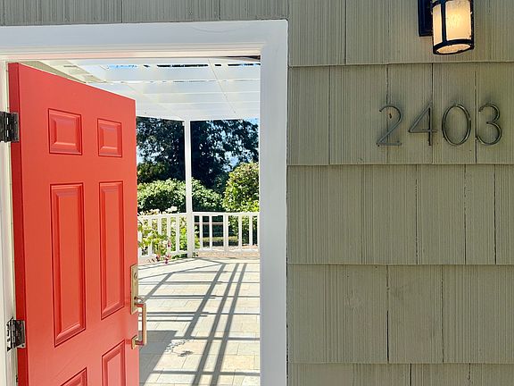 The entry surprisingly opens onto a welcoming, sunlit slate atrium that invites seamless indoor-outdoor living.