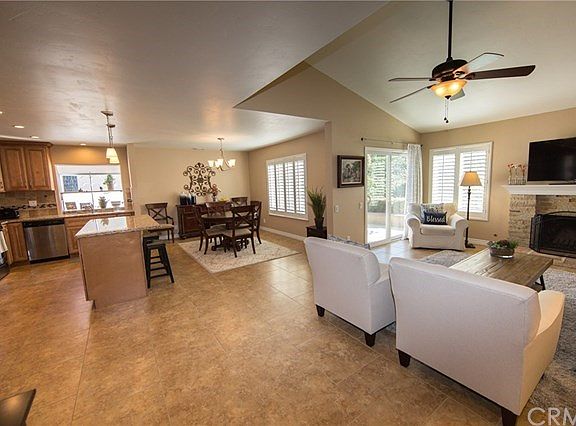 Open living space, note the warm colors in flooring, wall paint, kitchen cabinets and granite counters.