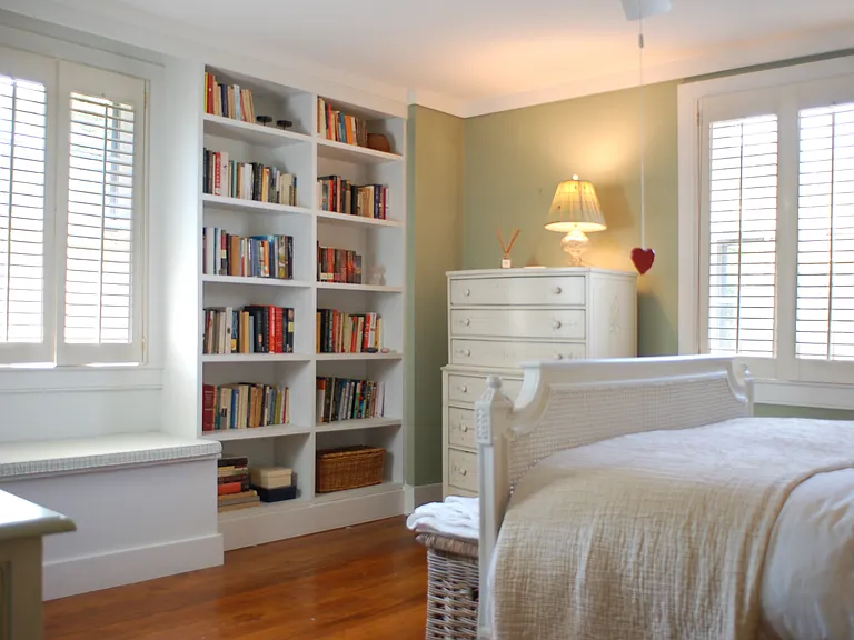 primary bedroom w/ built-in shelves
