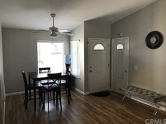 In living room looking towards front door. Front door, coat closet, dining area, and new laminate fl