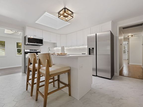 Fully remodeled kitchen w/new flooring, new cabinetry, and breakfast bar