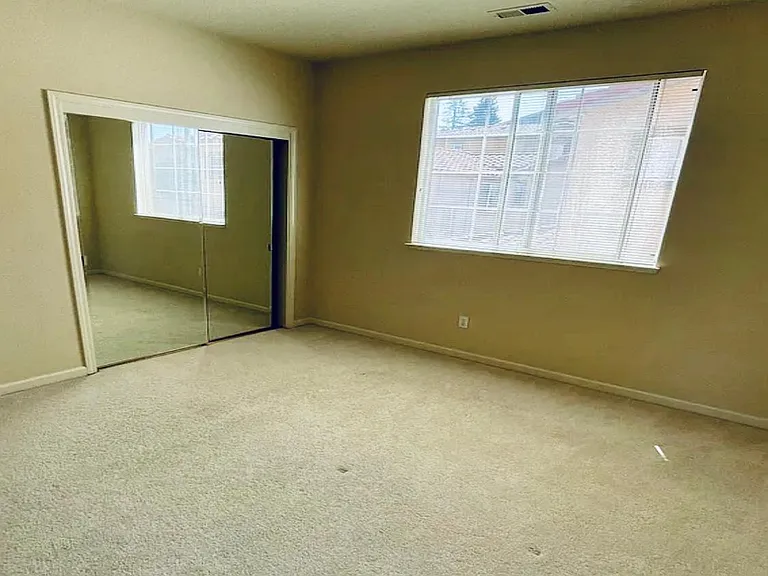 second bedroom with good size of closet. The wall is clean off-white color. Carpet is light beige.