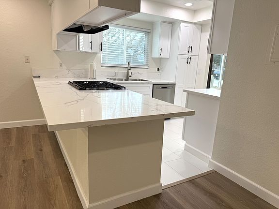 Kitchen quarz counter top with seating around two sides.