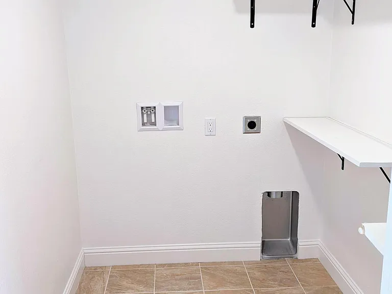 Laundry room with additional storage shelves. Brand new stainless steel washer-dryer will be installed soon.