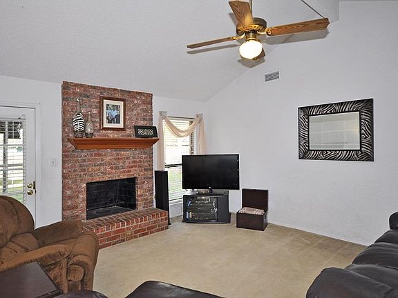 Living room with vaulted ceiling and French door to patio.