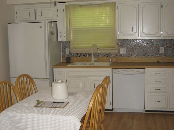 Bright white kitchen with custom mosiac back splash. Large