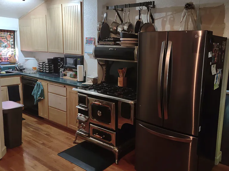 Kitchen with Heartland brand stove, LG french door refrigerator, dishwasher, and greenhouse type window above sink.
