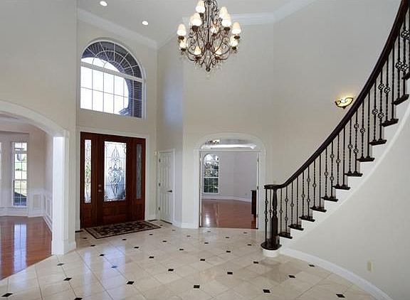 Breathtaking entry with leaded glass doors, winding staircase, high ceilings & huge windows!