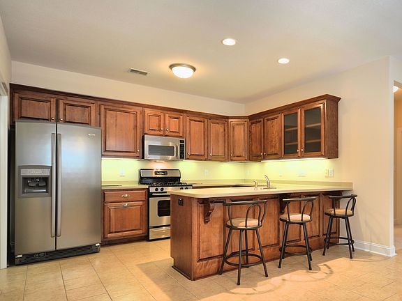 Kitchen with many cabinets and large refrigerator. 