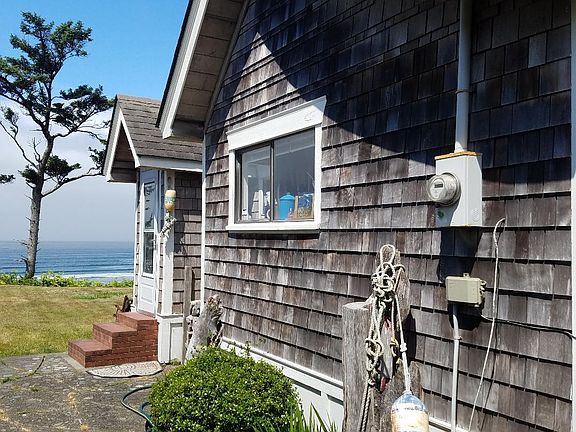 Storybook sway roof home with pebble stone patio
