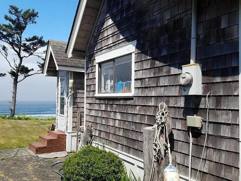 Storybook sway roof home with pebble stone patio