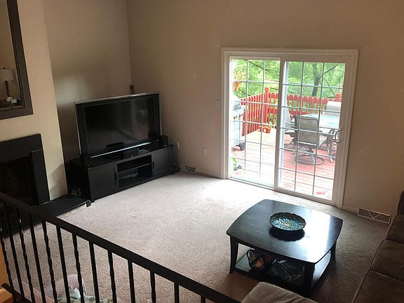 View of cozy sunken family room from dining room. (Note - tenants are NOT permitted to use fireplace.)