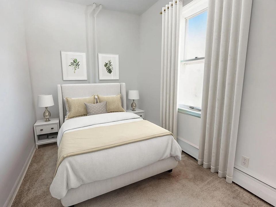 Bedroom with window facing park and small closet.