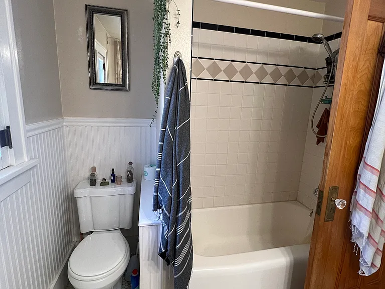 April 2026-Bathroom, pedestal sink, updated wall tile, original doors, full length mirror, beadboard walls