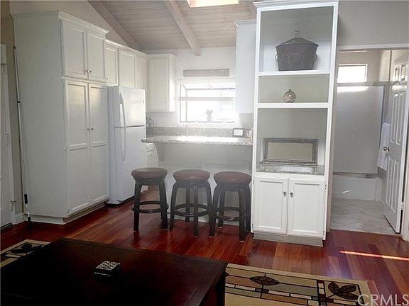 View of bright kitchen with bar area for sitting and view of