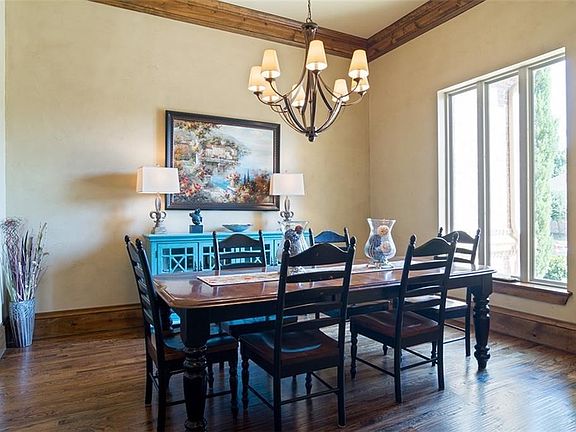 Spacious dining room accented by lots of natural light streaming through the large windows, knotty alder crown molding and baseboards and hand-scraped hardwood flooring.