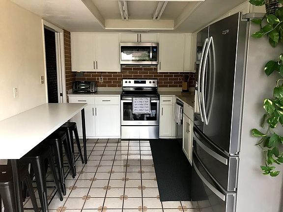 Renovated kitchen with brand new stainless steel appliances, brand new quartz counters, and brand new white shaker cabinets