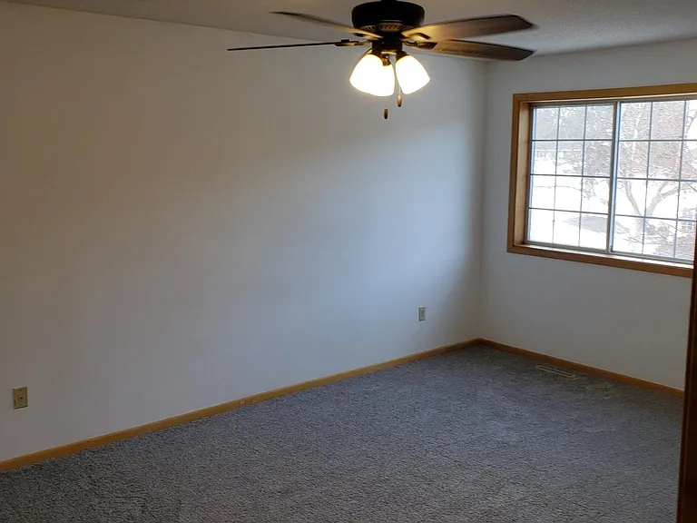 Large master bedroom with fan, blinds.