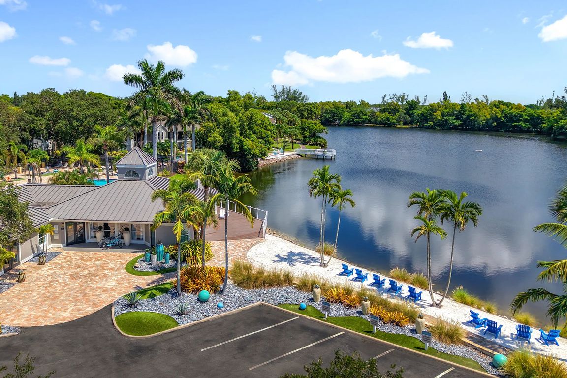River Reach blends luxury with nature at this serene lakefront clubhouse, complete with palm trees, Adirondack chairs, and private beach access steps from your front door.