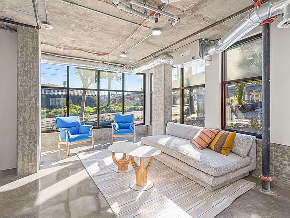 Experience the comfort and elegance of our spacious living room, featuring a cozy couch, stylish tables, and ample natural light.