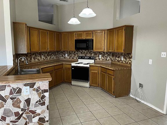 Here we're standing in the Kitchen eating area after just walking through the Dining room. The Kitchen has plenty of Cabinet space, Double Sinks, Electric Range/Oven, Microwave, Garbage Disposal, and Dishwasher.