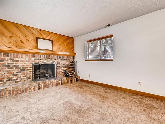 Spacious family room has cozy wood burning fireplace and mantle.