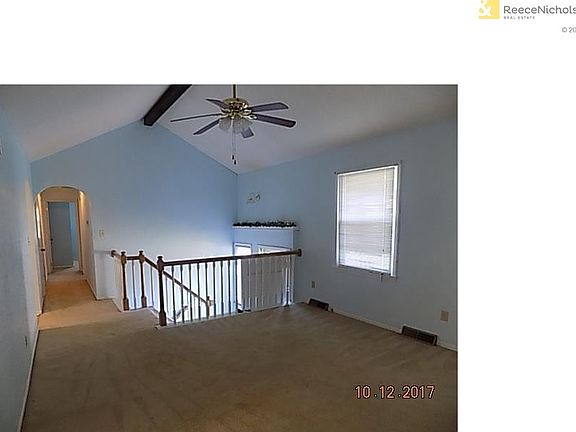 Living room with vaulted ceiling, blinds & ceiling fan.