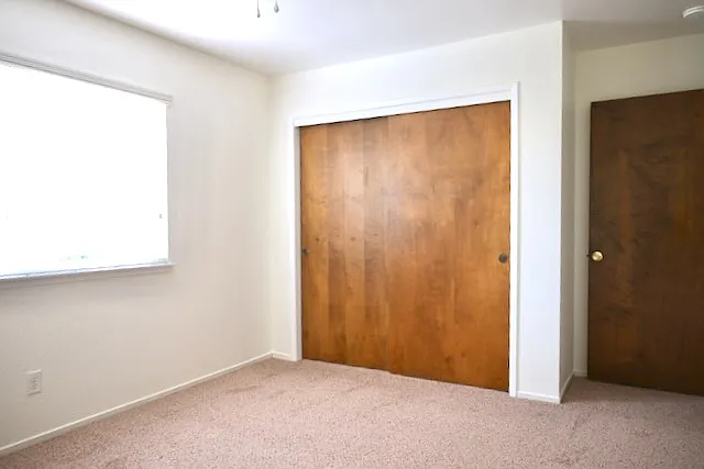 Airy light front bedroom with ceiling fan and spacious closet