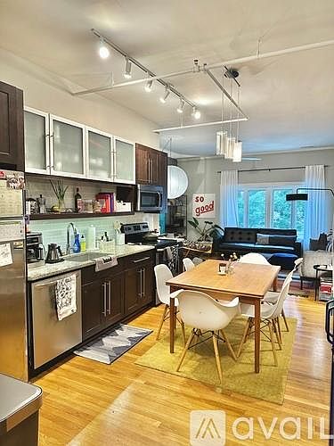 Open eat-in kitchen with open shelf, upgraded appliances and frosted cabinet fronts.