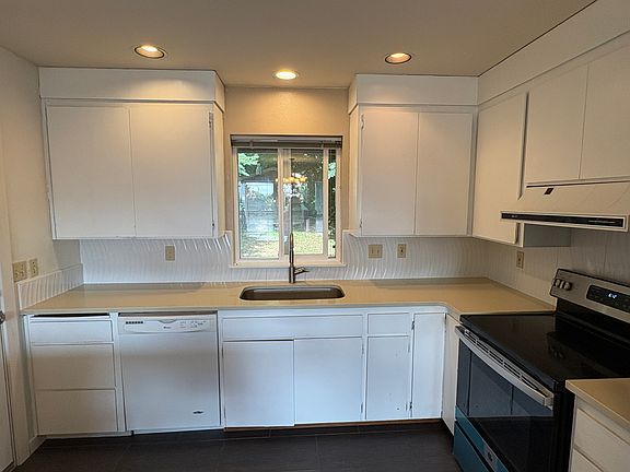 Kitchen view to shaded patio. Dishwasher, range.