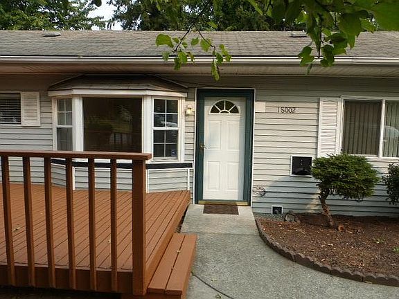 Welcoming deck on front of rambler home for cool relaxing.