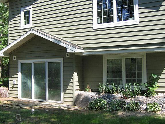 West side of home. Upper window is # 2 Bedroom window. Lower window and sliding door are (family room or mother in-law apartment windows.