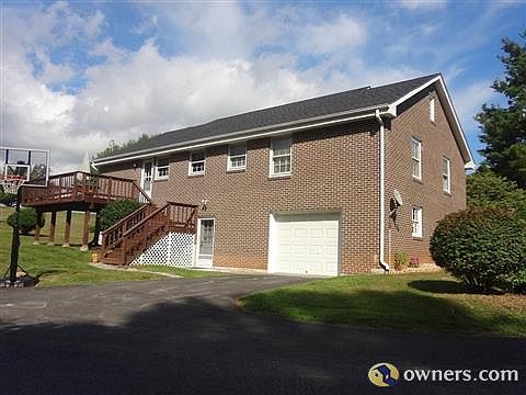 View of garage, deck, and paved driveway