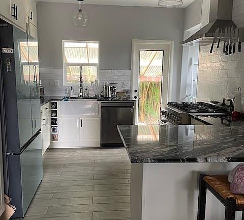 updated kitchen with all new appliances, granite countertops, apron-front sink and handy pullouts