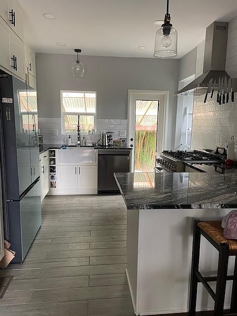 updated kitchen with all new appliances, granite countertops, apron-front sink and handy pullouts