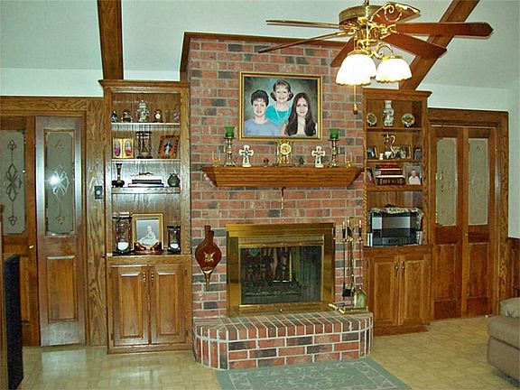 Fireplace wall with solid wood bifold doors with custom glass inserts.